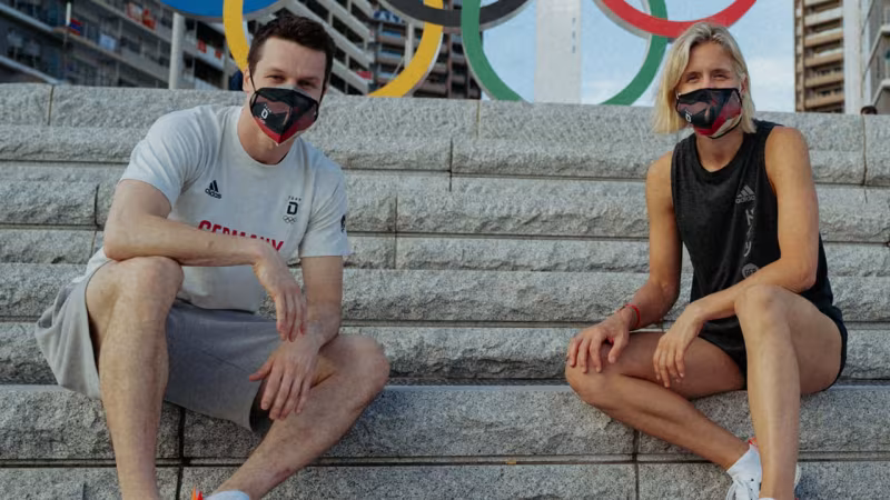 Laura Ludwig und Patrick Hausding tragen die Fahne ins Stadion